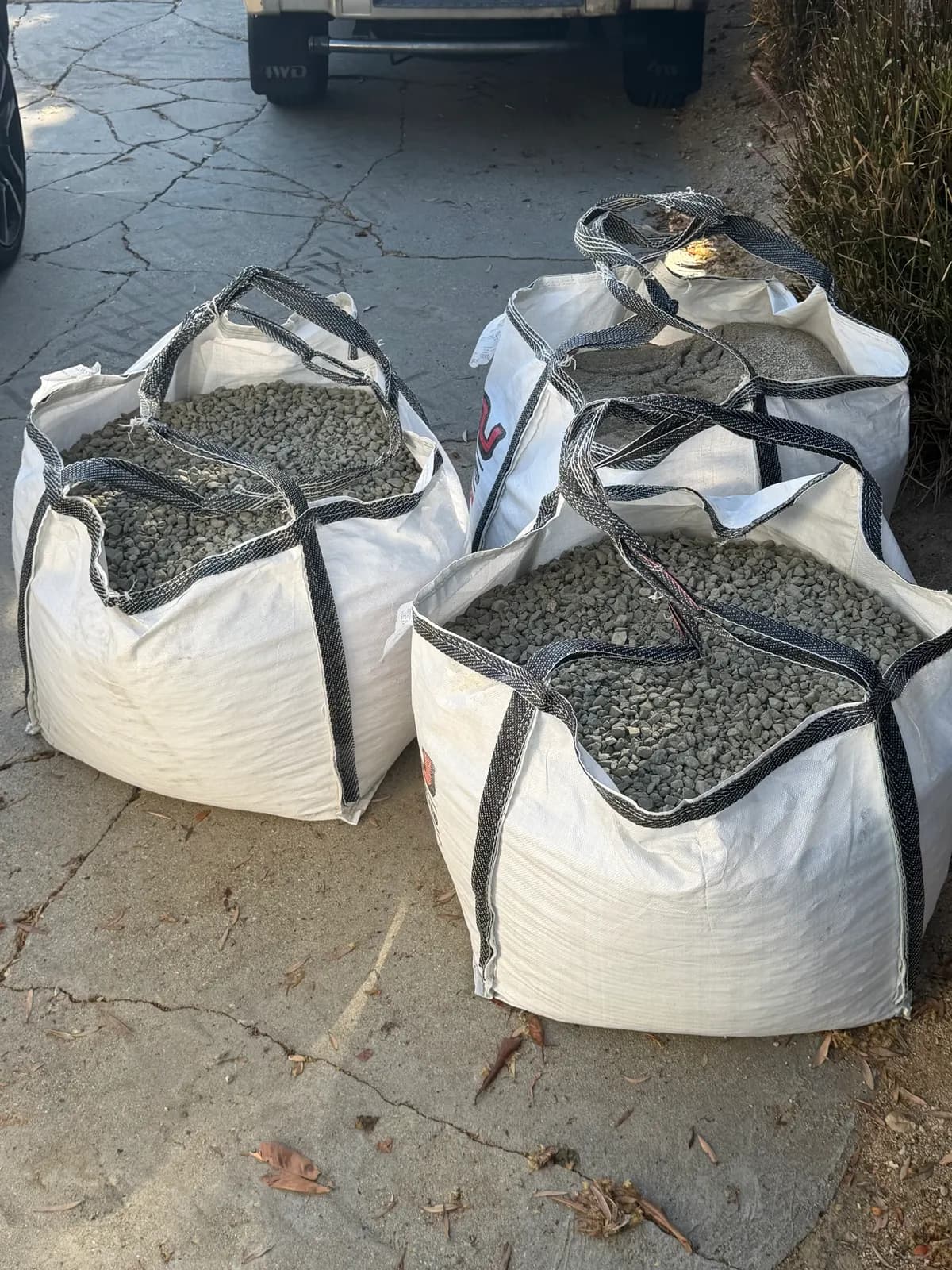 Four bulk bags of gravel and sand dropped in the driveway